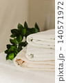 Minimalist still life of luxury spa essentials. White cotton towels with visible textured on a table. 140571972