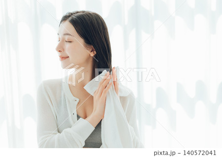 濡れた髪の毛をタオルで拭く若い女性 濡れた髪の毛をタオルで拭く若い女性 140572041