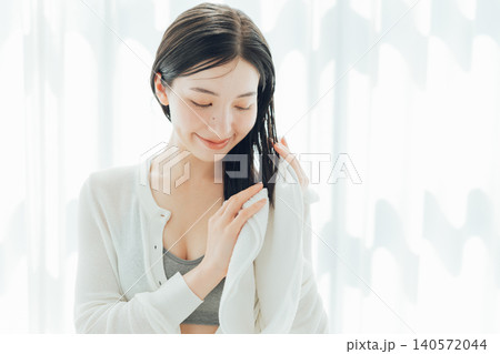 濡れた髪の毛をタオルで拭く若い女性 濡れた髪の毛をタオルで拭く若い女性 140572044
