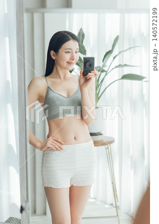 鍛えた体を鏡越しに自撮りをする女性 鍛えた体を鏡越しに自撮りをする女性 140572199