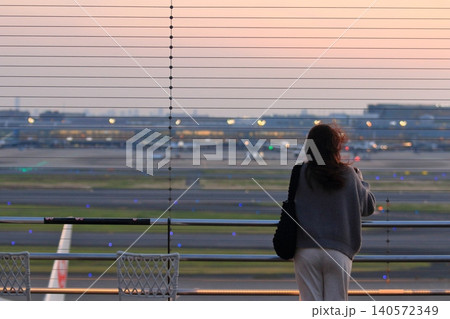 夕焼けの羽田空港を眺める女性 夕焼けの羽田空港を眺める女性 140572349