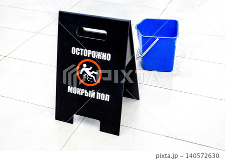 Inscription in russian Warning Wet Floor sign on a tile floor 140572630