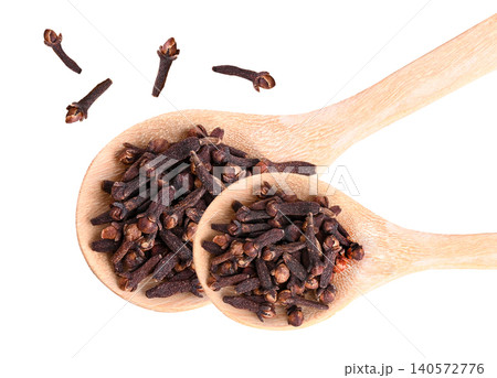 Top view of dried cloves on a wooden spoon, a beneficial herbal spice rich in natural wellness properties on white background. Top view of dried cloves on a wooden spoon, a beneficial herbal spice rich in natural wellness properties on white background. 140572776
