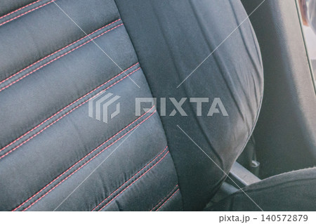 Extreme close up of a worn out and creased black leather car seat bolster, showcasing deep cracks, damage and signs of aging on the vehicle interior upholstery Extreme close up of a worn out and creased black leather car seat bolster, showcasing deep cracks, damage and signs of aging on the vehicle interior upholstery 140572879