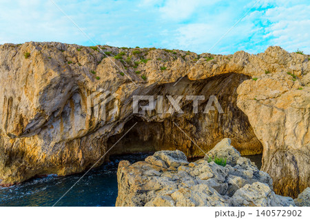 Explore the beauty of unique rock formations against a vibrant blue sky and tranquil waters 140572902