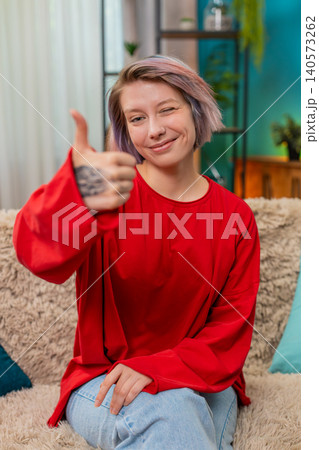 Happy woman showing thumbs up gesture, positive approval, agreement good feedback smiling cheerfully 140573262