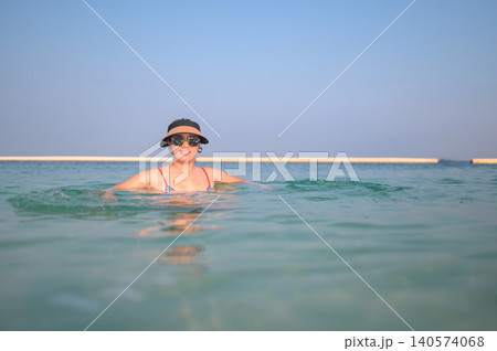 Asian Woman in Her 30s Enjoying a Relaxing Swim in Clear Water U Asian Woman in Her 30s Enjoying a Relaxing Swim in Clear Water U 140574068