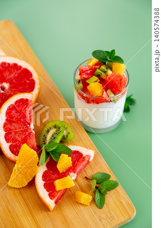 healthy breakfast yogurt with mixed fruits and mint on pastel background healthy breakfast yogurt with mixed fruits and mint on pastel background 140574388