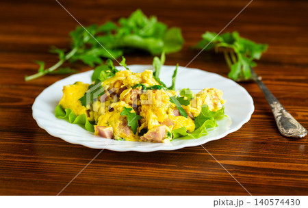 homemade scrambled eggs with greens on wooden table homemade scrambled eggs with greens on wooden table 140574430