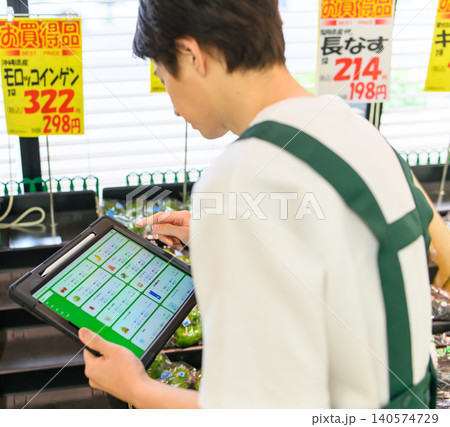 売り場で端末を確認する店員 140574729