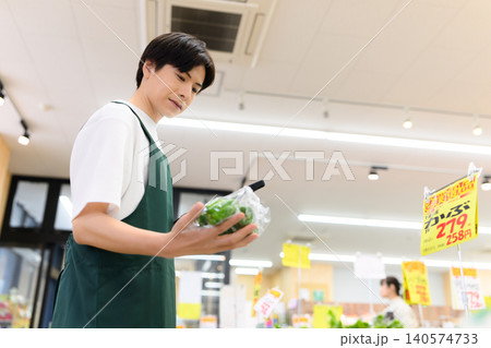 野菜を手にタブレット操作する店員 140574733