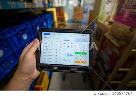 倉庫でタブレット端末を使って在庫管理する様子 140574764