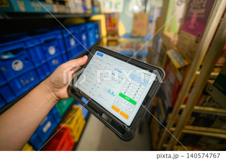 倉庫でタブレット端末を操作する手元 140574767