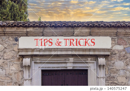 Tips and tricks words symbol. Concept words Tips and tricks on beautiful white sign plate. Beautiful stone wall background. Business tips and tricks motivational support concept. Copy space. Tips and tricks words symbol. Concept words Tips and tricks on beautiful white sign plate. Beautiful stone wall background. Business tips and tricks motivational support concept. Copy space. 140575247