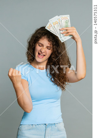Woman hold dollar cash money smiling satisfied celebrating salary savings loan financial success joy 140575311