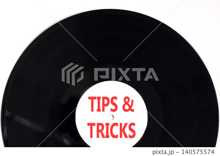 Tips and tricks words symbol. Concept words Tips and tricks on beautiful black vinyl disk. Beautiful white background. Business tips and tricks motivational support concept. Copy space. Tips and tricks words symbol. Concept words Tips and tricks on beautiful black vinyl disk. Beautiful white background. Business tips and tricks motivational support concept. Copy space. 140575574