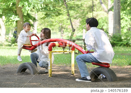 公園のシーソーを楽しむファミリー 公園のシーソーを楽しむファミリー 140576189