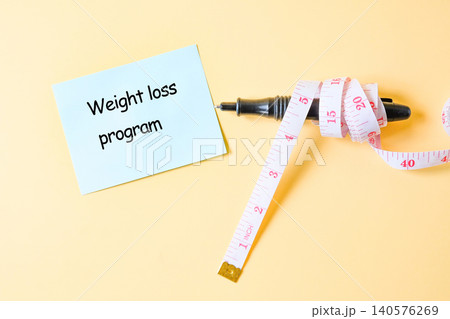 Wrap the measuring tape around the pen with paper note. Wrap the measuring tape around the pen with paper note. 140576269