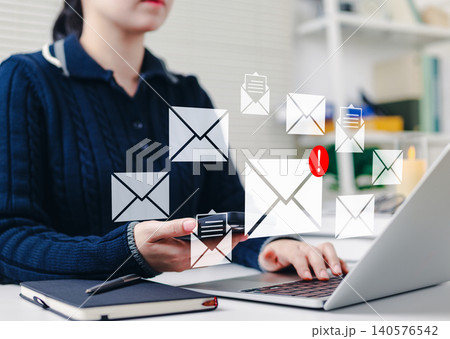Email notification and communication concept. Woman using laptop and smartphone with email icons, new message notifications, symbolizing digital communication, online messaging, and email marketing. 140576542