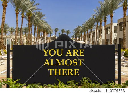 You are almost there symbol. Concept words You are almost there on beautiful black road sign. Beautiful blue sky background. Business You are almost there motivational support concept. Copy space 140576728