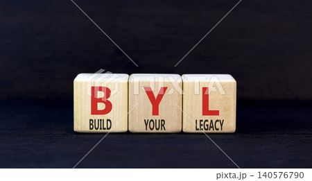 BYL build your legacy symbol. Concept words BYL build your legacy on beautiful wooden blocks. Beautiful black background. Business BYL build your legacy concept. Copy space BYL build your legacy symbol. Concept words BYL build your legacy on beautiful wooden blocks. Beautiful black background. Business BYL build your legacy concept. Copy space 140576790