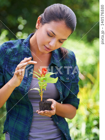Woman, gardening and plants with soil, flowers and hobby with fresh air or spring with earth day. Person, outdoor or girl with nature, peace or countryside with agriculture, growing or sustainability 140576880