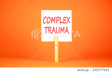 Complex trauma words symbol. Concept words Complex trauma on beautiful white paper on wooden clothespin. Beautiful orange background. Psychological complex trauma support concept. Copy space. Complex trauma words symbol. Concept words Complex trauma on beautiful white paper on wooden clothespin. Beautiful orange background. Psychological complex trauma support concept. Copy space. 140577043
