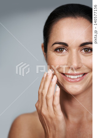 Smile, face cream and portrait of woman in studio with beauty, natural and anti aging routine. Happy, cosmetic and mature person with spf, lotion or sunscreen for dermatology by gray background. Smile, face cream and portrait of woman in studio with beauty, natural and anti aging routine. Happy, cosmetic and mature person with spf, lotion or sunscreen for dermatology by gray background. 140577156