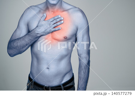 Medical, chest pain and man with discomfort in studio with inflammation, heartburn or injury. Red glow, shirtless and person with healthcare emergency, ache or strain by gray background with mockup. Medical, chest pain and man with discomfort in studio with inflammation, heartburn or injury. Red glow, shirtless and person with healthcare emergency, ache or strain by gray background with mockup. 140577279
