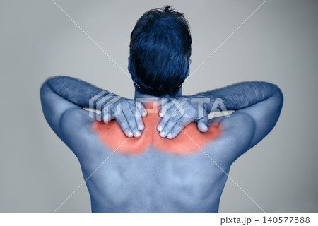Studio, man and hands for shoulder pain or tension with muscle inflammation, discomfort and sprain of stress or strain. Red glow, back view and person with ache, injury and bruise on grey background 140577388