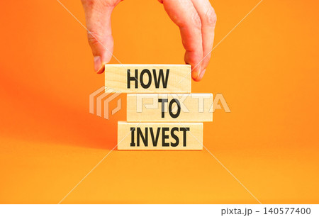 How to invest words symbol. Concept words How to invest on beautiful wooden blocks. Beautiful orange background. Businessman hand. Business and how to invest concept. Copy space. How to invest words symbol. Concept words How to invest on beautiful wooden blocks. Beautiful orange background. Businessman hand. Business and how to invest concept. Copy space. 140577400