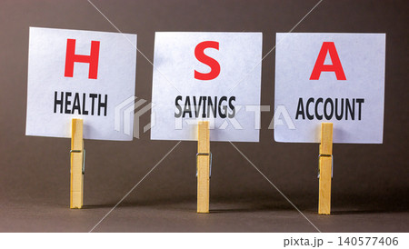 HSA health saving account symbol. Concept words HSA health saving account on beautiful white papers on clothespins. Beautiful grey background. Medical HSA health saving account concept. Copy space. HSA health saving account symbol. Concept words HSA health saving account on beautiful white papers on clothespins. Beautiful grey background. Medical HSA health saving account concept. Copy space. 140577406