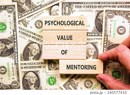 Value of mentoring symbol. Concept words Psychological value of mentoring on beautiful wooden blocks. Beautiful dollar bills background. Business psychological value of mentoring concept. Copy space. 140577410