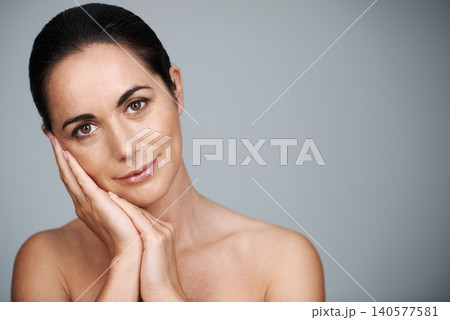 Portrait, mature and skincare of woman touching face in makeup at studio isolated on gray background. Cosmetics, hands or beauty of model in treatment for dermatology, anti aging and mockup space Portrait, mature and skincare of woman touching face in makeup at studio isolated on gray background. Cosmetics, hands or beauty of model in treatment for dermatology, anti aging and mockup space 140577581