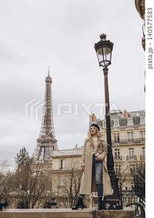 Stylish woman in trench coat posing near the Eiffel Tower in Paris Stylish woman in trench coat posing near the Eiffel Tower in Paris 140577583
