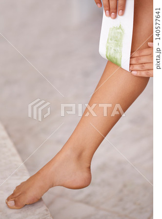 Closeup, leg and woman with waxing, luxury and wellness with dermatology and pamper in a bathroom. Person, lady and girl with hair removal and cosmetics with skincare and smooth with healthy skin 140577641