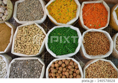 Vibrant display of colorful spices and nuts at a bustling market in the heart of an exotic town 140578028