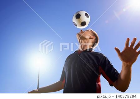 Football, bounce and head with man, game and training with competition, sunshine and exercise. Blue sky, lens flare and player with practice or athlete with skills or technique with fitness or soccer Football, bounce and head with man, game and training with competition, sunshine and exercise. Blue sky, lens flare and player with practice or athlete with skills or technique with fitness or soccer 140578294