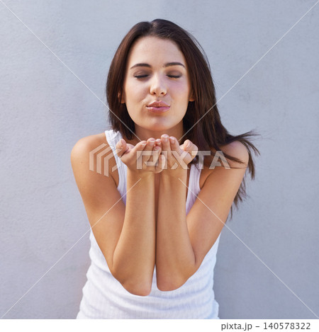 Face, happy and blowing kiss with woman on gray wall background for flirting, love or romance. Model, affection and emoji with hand gesture of young person feeling satisfied on valentines day Face, happy and blowing kiss with woman on gray wall background for flirting, love or romance. Model, affection and emoji with hand gesture of young person feeling satisfied on valentines day 140578322