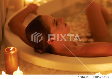 Woman, bath and candle light for relax spa or self care cleaning for routine with bubbles for treatment, hygiene or wellness. Female person, face and stress relief skincare with peace, tub or comfort Woman, bath and candle light for relax spa or self care cleaning for routine with bubbles for treatment, hygiene or wellness. Female person, face and stress relief skincare with peace, tub or comfort 140578395