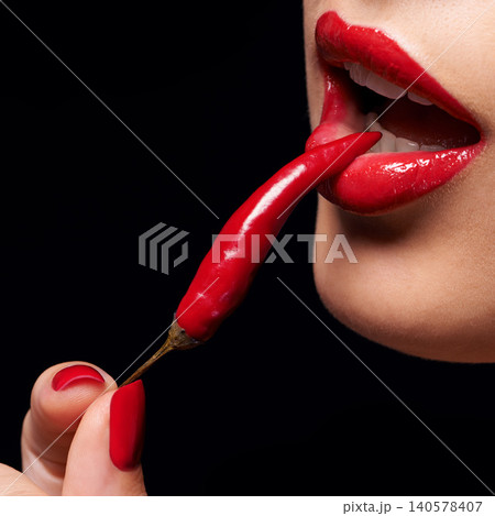 Chili, red lipstick and closeup of woman lips in studio with trendy, beauty and manicure treatment. Mouth, cosmetics and female person with nail polish eat pepper for cosmetology by black background. Chili, red lipstick and closeup of woman lips in studio with trendy, beauty and manicure treatment. Mouth, cosmetics and female person with nail polish eat pepper for cosmetology by black background. 140578407