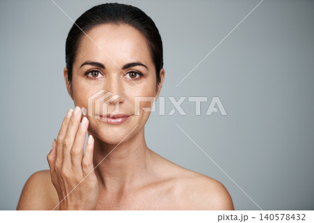 Portrait, woman and face cream in studio for anti aging, skincare and cosmetics in gray background. Female person, moisturizer and daily routine or self care, confidence and skin tone in mockup space Portrait, woman and face cream in studio for anti aging, skincare and cosmetics in gray background. Female person, moisturizer and daily routine or self care, confidence and skin tone in mockup space 140578432