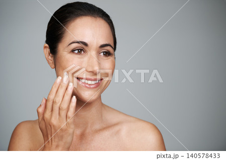 Face cream, beauty and mature woman in studio for skincare, natural and face treatment. Smile, cosmetic and female person with spf, lotion or sunscreen for dermatology routine by gray background. 140578433