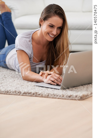 Woman, smile and laptop on floor with reading for blogging, communication and email on mat in living room of home. Person, happy and technology on ground with relax, streaming show and watching video Woman, smile and laptop on floor with reading for blogging, communication and email on mat in living room of home. Person, happy and technology on ground with relax, streaming show and watching video 140578475