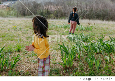 Two Children Exploring a Grassy Hillside in Nature Two Children Exploring a Grassy Hillside in Nature 140578617