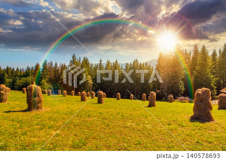 sunset over rural landscape with coniferous forest on a green hill. spruce trees on grassy meadow in tatra mountains. summer vacation in poland. weather with rainbow sunset over rural landscape with coniferous forest on a green hill. spruce trees on grassy meadow in tatra mountains. summer vacation in poland. weather with rainbow 140578693