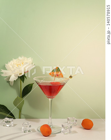 Modern still life with pink martini, summer alcoholic cocktail with apricot for party and peonies on elegant modern background, minimalist concept for bar, cafe, advertising banner Modern still life with pink martini, summer alcoholic cocktail with apricot for party and peonies on elegant modern background, minimalist concept for bar, cafe, advertising banner 140578915