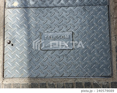 Cordoba, Argentina - April 9, 2026: Telecom utility manhole cover installed in a city sidewalk in Cordoba 140579089