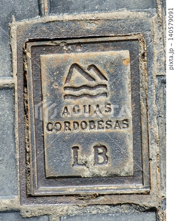 Cordoba, Argentina - April 9, 2026: Aguas Cordobesas cast iron utility cover on a city sidewalk 140579091