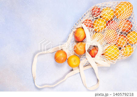 Reusable net bag holding fresh citrus fruits Reusable net bag holding fresh citrus fruits 140579218